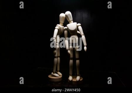 One  wooden figurines comforting another one Stock Photo