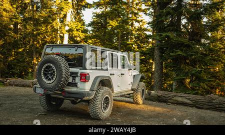 Jeep Wrangler Rubicon side view. white offroad 4-door SUV parked in the forest. Compact four wheel drive off road and sport utility vehicle. Jeep Wran Stock Photo