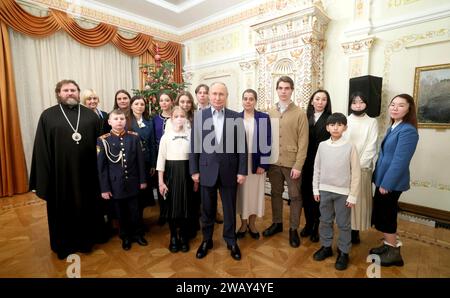 Novo-Ogaryovo, Russia. 07th Jan, 2024. Russian President Vladimir Putin, center, and Archbishop Nikolay Mosolov, left, pose with military families following Orthodox Christmas celebrations at the Church of the Icon of Savior Not Made by Hands at the official presidential compound, January 7, 2024 in Novo-Ogaryovo, Moscow Oblast, Russia. Putin hosted families of soldiers killed in the Ukraine war for the celebration. Credit: Gavriil Grigorov/Kremlin Pool/Alamy Live News Stock Photo