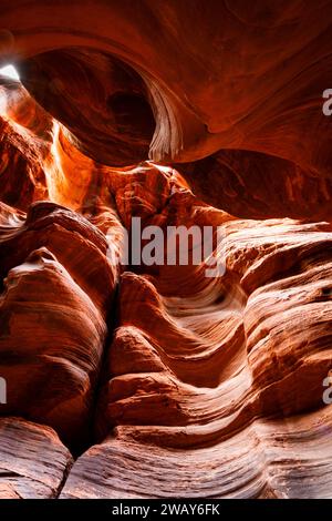 An aerial view of an expansive canyon, set against a backdrop of rocky cliffs, with the sun shining down on the canyon walls Stock Photo