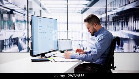 Businessperson Analyzing Invoice On Computer In Office Stock Photo