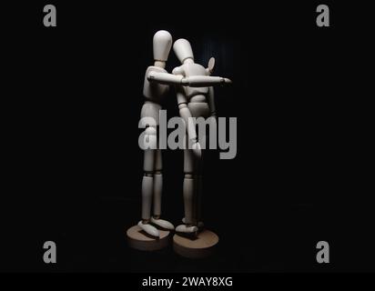 One  wooden figurines comforting another one Stock Photo