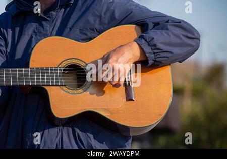 An artist playing guitar on the street. close-up details of a classical guitar Stock Photo