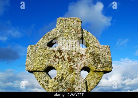 Old Celtic cross on sky background. Stone cross. Stock Photo