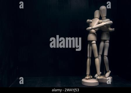 One  wooden figurines comforting another one Stock Photo