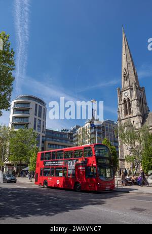 UK, England, London, Ealing Broadway, New Broadway with Red London Double-Decker Bus passing Christ the Saviour Parish Church Stock Photo
