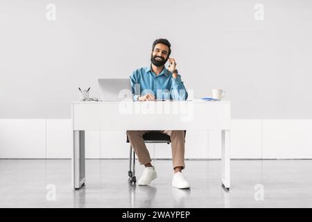 Relaxed businessman on a phone call at workdesk Stock Photo