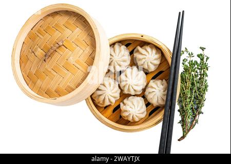 Steamed baozi dumplings stuffed with meat in a bamboo steamer. Isolated on white background, top view Stock Photo