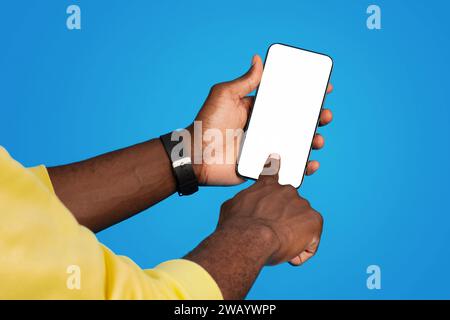 Close-up of a Black man's hands holding a smartphone with a blank white screen Stock Photo