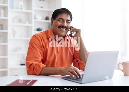 Middle aged eastern businessman talking on cellphone with client Stock Photo