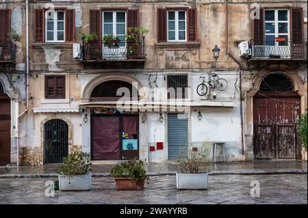 Palermo, Sicily, Italy, 15 December 2023 - Old facade with wooden shutters and a bike in old town Stock Photo
