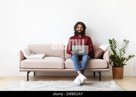 Handsome indian man using laptop at home Stock Photo