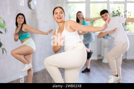Teenagers practicing breakdance toprock moves in training hall. Teenagers engaged in breakdance Stock Photo