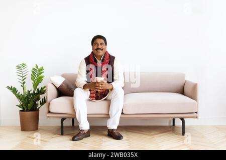 Happy hindu man enjoying morning coffee at home Stock Photo