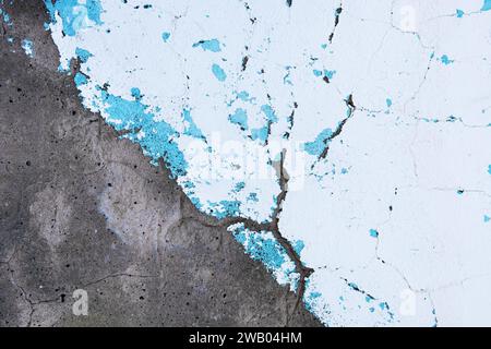 Abstract background of old shabby concrete wall surface with bright turquoise and white paint and weathered parts. Vintage decorative elements. Stock Photo