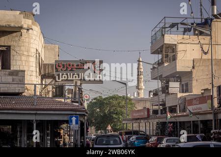 The street of Palestinian city of Bethlehem, with houses, cars, and mosque minaret in the background, at Palestinian territory of West Bank, Palestine Stock Photo