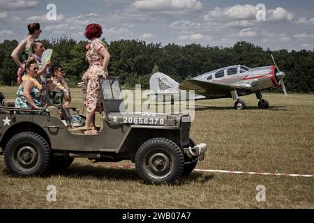 Pin-ups standing on a jeep Willys looking at Spartan Executive 7 W ready to take-off Stock Photo