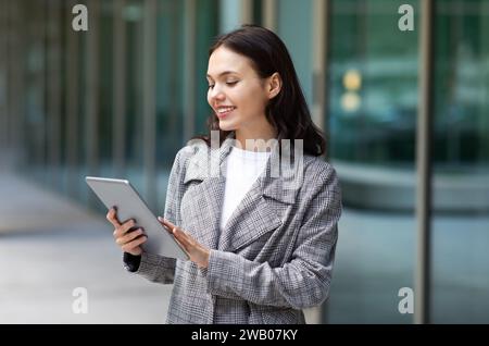 European entrepreneur woman using her digital tablet on city street Stock Photo