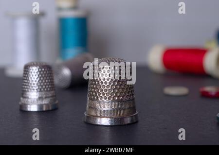 Sewing tools, thimbles, thread spools and buttons used in tailoring. Stock Photo