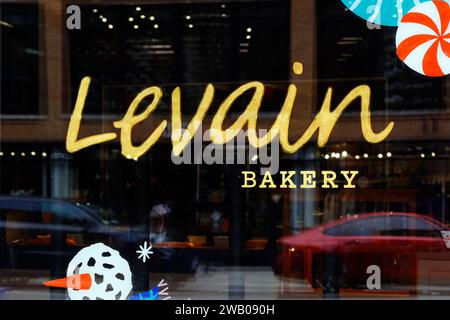 Window signage at a Levain Bakery in New York. The bakery specializes in thick cut chocolate chip cookies Stock Photo