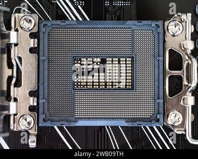 Closeup top view of a CPU socket on a black motherboard, semiconductor electronic industry, printed circuit board, computer science Stock Photo