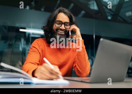 Positive indian man entrepreneur working at modern office Stock Photo