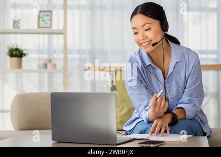 Positive millennial chinese woman working or studying from home Stock Photo