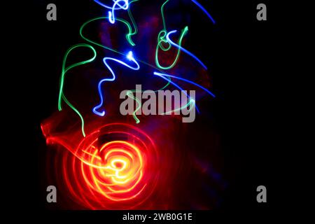 Bright lights on a black background - abstract motion in light painting. Stock Photo