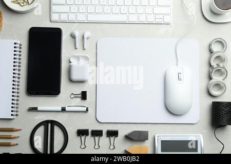 Flat lay composition with wired computer mouse and stationery on light grey table. Space for text Stock Photo
