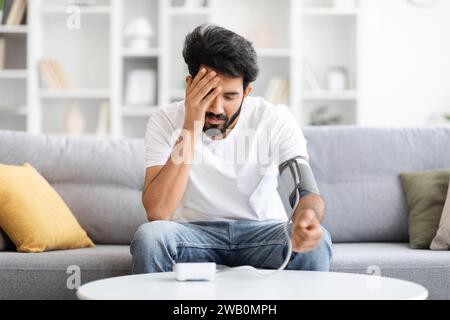 Indian man on home table opens laptop with cheerful smile and starts ...