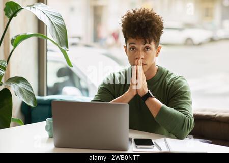 Portrait of pensive young black guy entrepreneur working at cafe Stock Photo