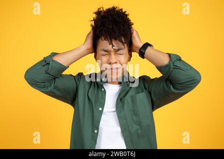 Stressed young african american guy touching his head Stock Photo