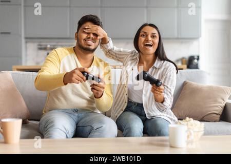 Cheerful Young Indian Couple Having Fun At Home, Playing Video Games Together Stock Photo