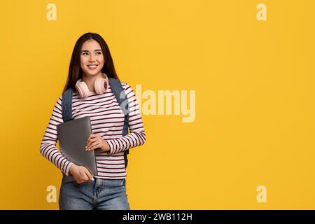 Happy young asian lady student holding laptop Stock Photo
