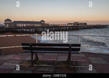 Hastings, East Sussex, England, UK - May 11, 2022: Evening mood on the beach, with a bench overlooking the the pier Stock Photo