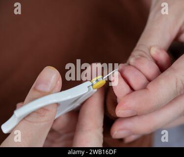 Mom cuts her newborn son's fingernails with small children's scissors. Stock Photo