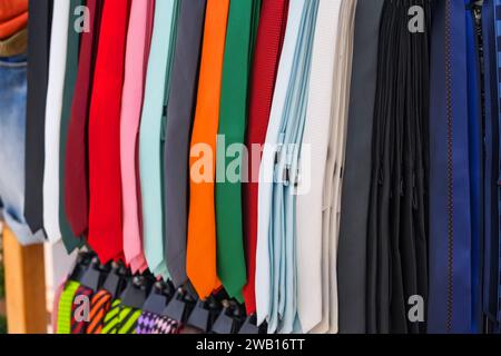 Many different ties of multi colors on display at the exhibition showcase. Large assortment of items for customers to choose from. Stock Photo