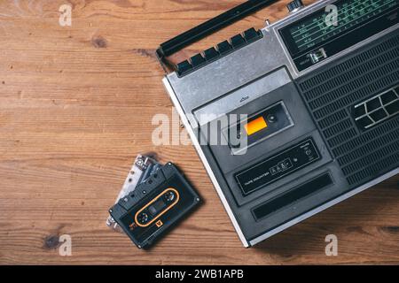 Vintage portable radio with cassette tape player on the wooden table. Music listening concept. Stock Photo