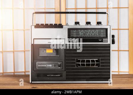 Vintage portable radio with cassette tape player on the wooden table. Music listening concept. Stock Photo