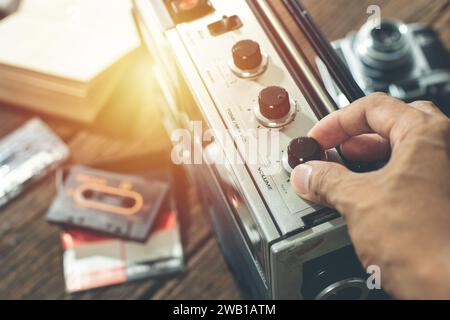 The man turning knob of vintage radio. Music listening concept. Stock Photo