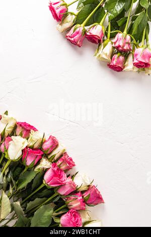 Beautiful vertical festive background with two bouquets of white and pink tea roses. Blank space for your text. border. frame. postcard Stock Photo