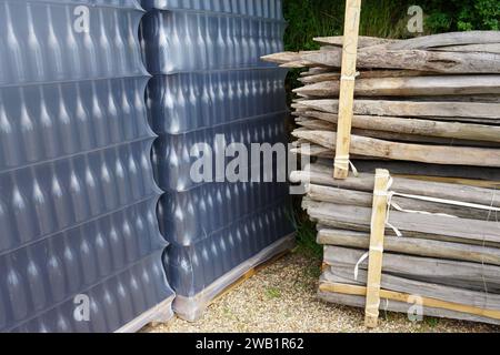 rows of empty wine bottles on pallet in plastic by old wooden stakes in a cellar in the loire valley, france Stock Photo