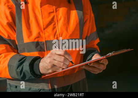 Architect and construction engineer making notes and remarks during building site inspection, selective focus Stock Photo