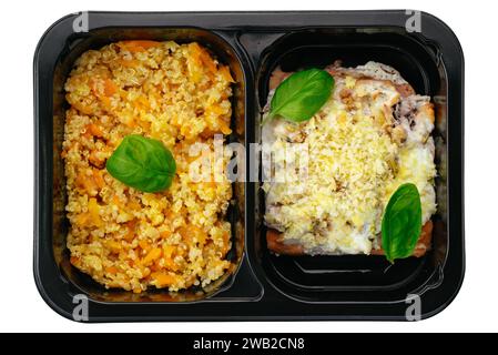 baked fish with sauce, side dish of bulgur and vegetables in lun Stock Photo