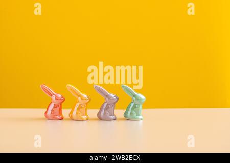 easter concept backdrop. Cheerful Ceramic Bunnies on Yellow. Stock Photo