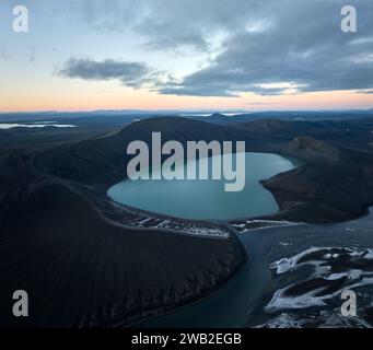 Aerial view of a serene pond surrounded by lush green meadows, dense ...
