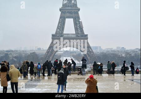 Unexpected snow in Paris. At Trocadéro Square, many tourists take souvenir photos with the Eiffel Tower in the background. Stock Photo