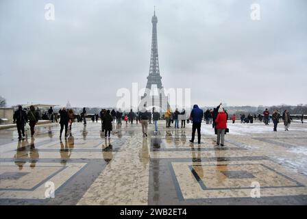 Unexpected snow in Paris. At Trocadéro Square, many tourists take souvenir photos with the Eiffel Tower in the background. Stock Photo