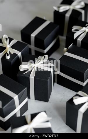 Black gift boxes with white ribbon on a white table Stock Photo