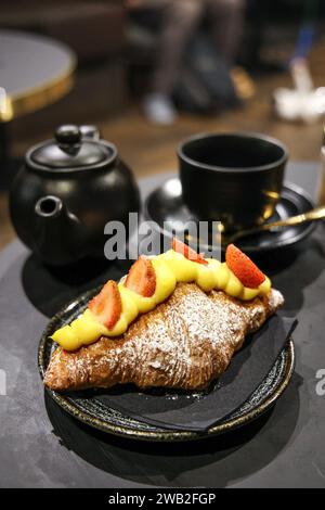 Croissant with strawberries at with tea at Java Whiskers Cat Cafe, London, England Stock Photo